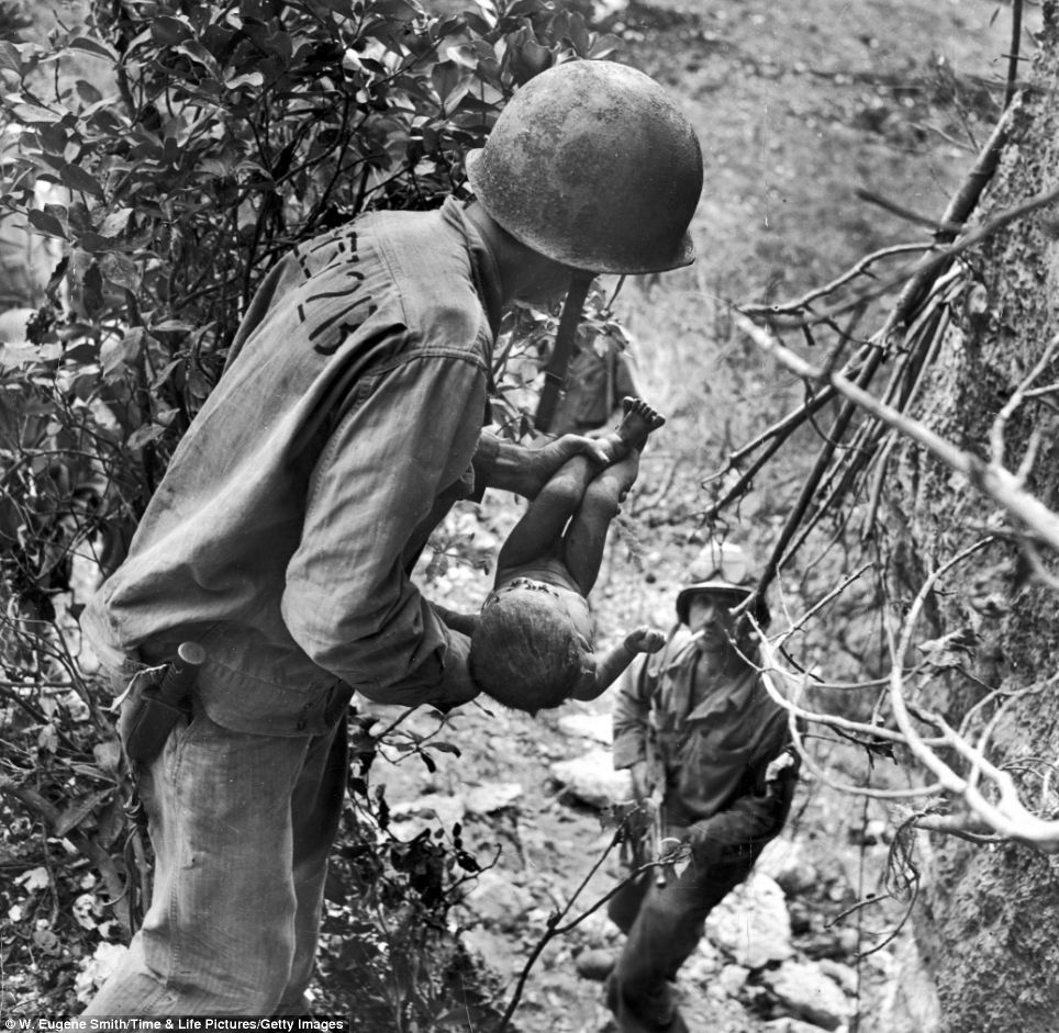 Un marine soulève un nourrisson presque mort d’une grotte où les insulaires s’étaient cachés pendant la bataille de Saipan – W.E. Smith – juillet 1944